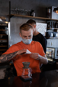 穿着橙色T恤的金发男子 准备替代咖啡酿制 现代阁楼咖啡店中的化学橙子咖啡师咖啡馆微笑商业咖啡机饮料店铺施工男性图片