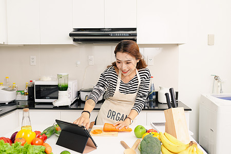 年轻的亚洲女性使用平板电脑 食品协调员 营养学家饮食厨师生产微笑女孩家庭主妇女士厨房药片图片