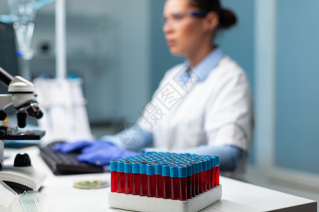 选择性地把重点放在透明 有血迹的真空剂上 放在桌上玻璃药品女士实验室化学品样本科学家科学内阁生物学家背景图片