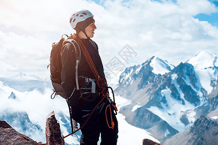 旅行者正在雪山上远足蓝色太阳运动旅行齿轮背包游客旅游男人顶峰图片