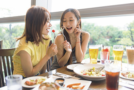 快乐的年轻女子在餐厅享受食物和饮料沙拉酒吧女士会议女性酒精蔬菜闲暇庆典女孩们图片