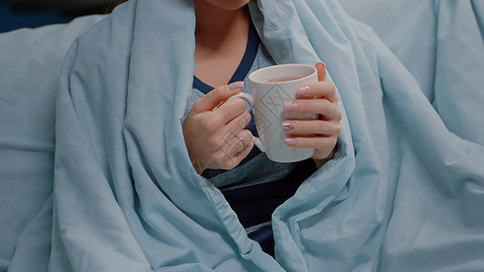 近身的生病女人 用毯子抱着茶杯图片