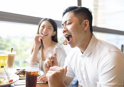 在餐厅吃午饭时玩得开心的情侣喜悦烧烤午餐乐趣快乐女朋友女性酒吧男朋友杯子图片