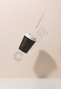 棕色纸板杯 有白色塑料盖和木棍 在白桌子上悬浮 Beige 背景 咖啡店模板图片