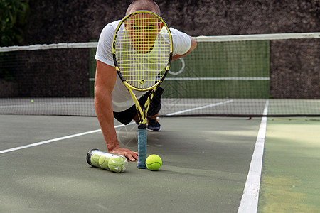 男性手握网球和打网球棒娱乐运动装法庭游戏运动男生黄色闲暇爱好运动员图片