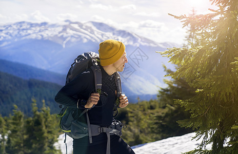 一个带着背包的年轻笑脸男人悬崖男性森林荒野旅行保暖假期娱乐运动季节图片