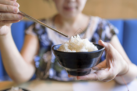 握着一碗美味美食煮白饭的女子手图片