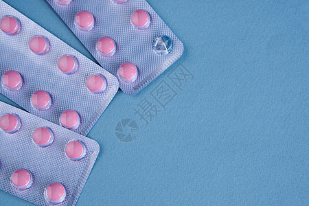 粉色药丸包装维生素止痛药蓝色背景红色药品化学品制药宏观抗生素治愈白色药剂科学图片
