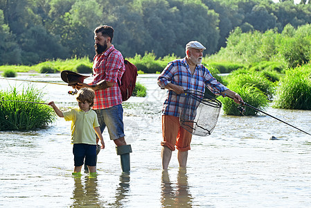 男人节 家庭纽带 飞钓者在河中使用飞钓竿 飞钓鳟鱼 祖父和孙子 曾祖父和曾孙图片