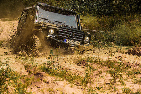 越野 4x4 旅行徒步旅行 运动车轮轮胎和越野 与大 4x4 汽车的旅行概念 拉力赛 泥泞是通过湿泥或粘土区域的越野 吉普车户外背景图片