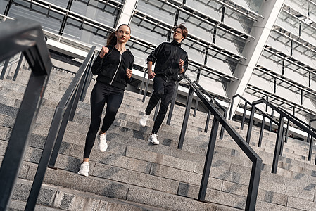 一大早健身 小情侣在楼下奔跑女士楼梯女性夫妻脚步训练旅行慢跑者男人慢跑图片