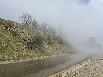 在山地的雾中紧靠湿路 在雾和多云的天气下雨水后行驶道路图片