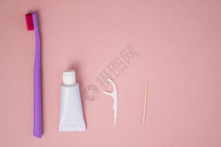 粉红色背景的个人口腔卫生产品 牙刷管牙膏牙膏牙签和牙线 平铺图片