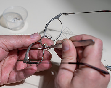 安装戴眼镜的鼻罩 一名男技工修理破损的眼镜眼睛验光师框架配镜师螺丝刀制造业卫生鼻子肋骨器皿图片