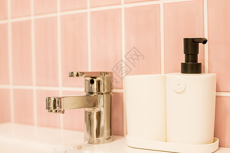 带大理石台面的镀铬水龙头 白色水槽 浴室内的豪华水龙头混合器 浴缸和水龙头 银水龙头附近瓶分配器中的肥皂 卫生预防概念 选择性聚图片