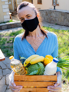 一名女性志愿者 为在冠状病毒流行期间面临风险的老年人提供一篮子粮食供应图片