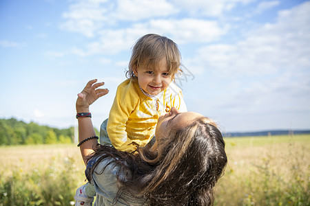 快乐的妈妈和婴儿 在田里玩 夏天在阳光明媚的日子里儿子生活母性孩子日落家庭草地公园童年晴天图片