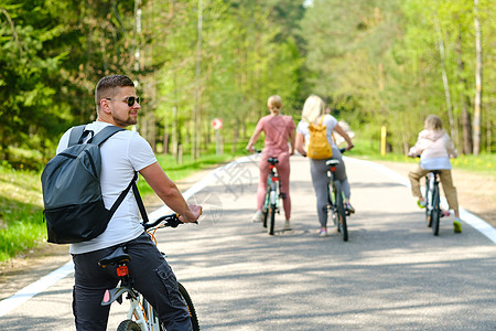 一群背着背包的骑自行车者在享受大自然的森林公路上骑自行车晴天自由乐趣朋友们行动女士家庭假期男人旅行图片