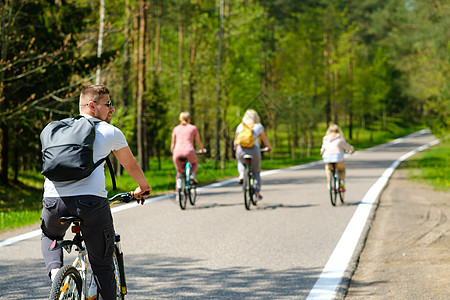 一群背着背包的骑自行车者在享受大自然的森林公路上骑自行车成人冒险行动家庭晴天空间假期自由娱乐男人图片