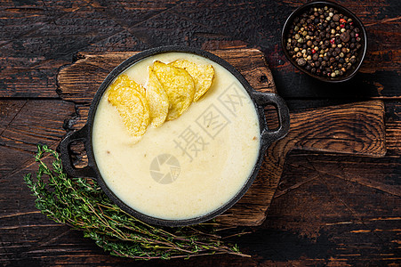 木板上的土豆薯片 黑木背景的土豆酱汤 顶层风景勺子食物美食熏肉盘子午餐奶油草本植物营养蔬菜图片