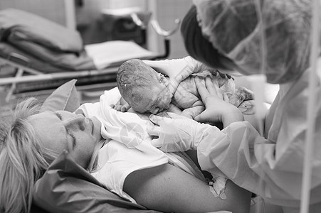 新生儿在医院产科病房的母亲胸骨上的特写镜头 刚出生 黑白照片图片