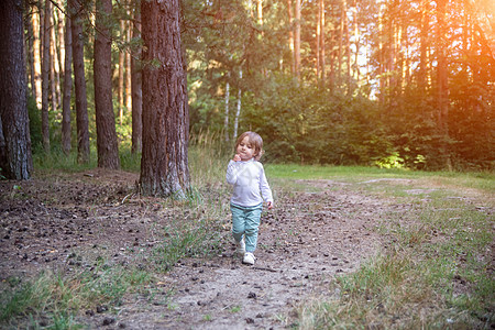 可爱的小孩在树林里走来走去图片