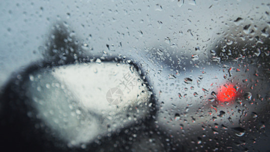 雨天的汽车玻璃杯  不专注的背景 挡风玻璃擦拭器中的移动水滴图片