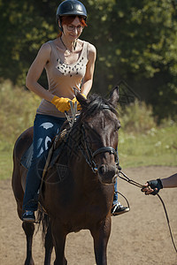 骑马课程骑马的年轻女子闲暇骑术骑士女孩运动树木女骑士马背头盔服饰图片