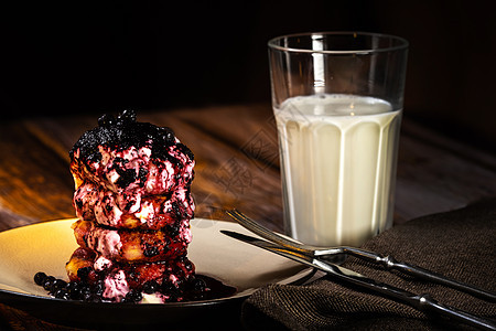 炸奶酪蛋糕加蓝莓果酱和酸奶油 在盘子上和一杯牛奶在桌上甜点饮食背景早餐黑色食物美食水果煎饼浆果图片
