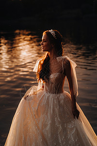 穿着白色礼服的优雅新娘在日落时享受自然 在公园里穿着天生的婚纱赤脚花束裙子婚礼婚姻自由女士瀑布旅行女孩图片