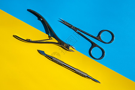 黄色和蓝色背景上的一组消毒修指甲或修脚工具角质层推子和剪刀 用于安全卫生 美容和指甲护理 复制空间图片
