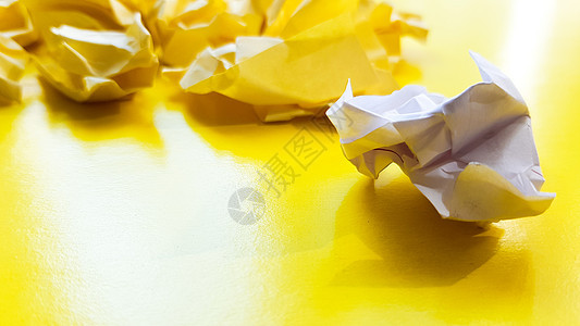 在黄色背景上隔离的球皱巴巴的纸球 纹理的弄皱的纸 集思广益后弄皱的纸被扔进了垃圾箱 黄色背景上的一张黄色皱巴巴的纸垃圾挫折篮子空图片