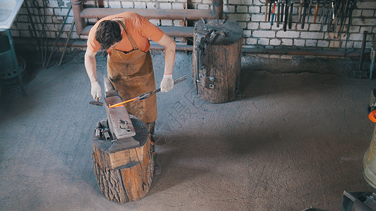 钢铁铁铁匠在铁架上制造金属工具 用锤子 顶视线图片