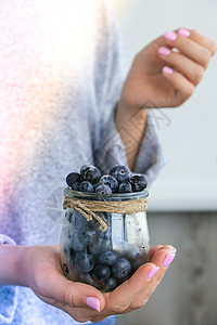 女人拿着装有冷冻蓝莓水果的碗 收获的概念 收集浆果的女性手 健康饮食理念 为冬天储备浆果 素食 vegan food收成覆盆子养图片