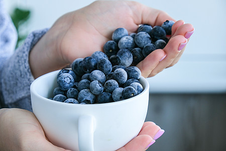 女人拿着装有冷冻蓝莓水果的碗 收获的概念 收集浆果的女性手 健康饮食理念 为冬天储备浆果 素食 vegan food养分节食甜点图片