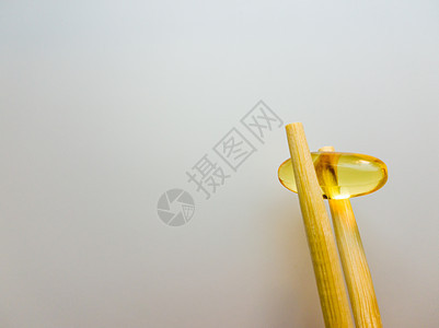 鱼油胶囊用中国筷子 在白色背景上的欧米茄 3 高分辨率产品 食物供给 健康生活方式的维生素 脂肪酸 体内新陈代谢工作室药品药片愈图片
