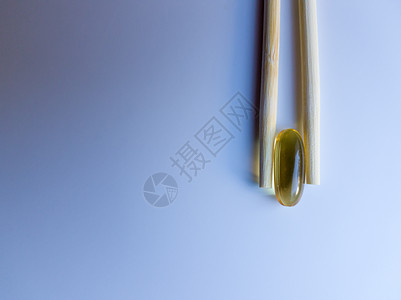 鱼油胶囊用中国筷子 在白色背景上的欧米茄 3 高分辨率产品 食物供给 健康生活方式的维生素 脂肪酸 体内新陈代谢团体胶囊愈合竹子图片
