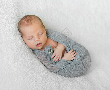 用张开的嘴 抱着小玩具 包着睡着的婴儿图片