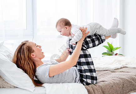 母亲在床上生儿育女孩子生活母性妈妈女性卧室喜悦睡衣家庭儿子图片