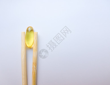鱼油胶囊用中国筷子 在白色背景上的欧米茄 3 高分辨率产品 食物供给 健康生活方式的维生素 脂肪酸 体内新陈代谢愈合宏观处方药品图片