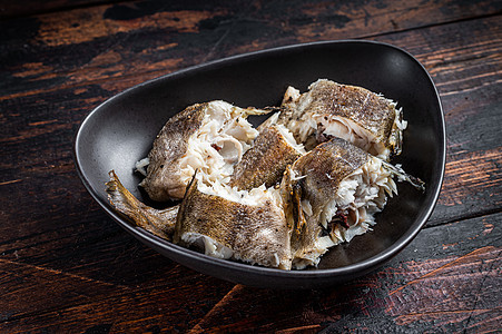盘子里的烤鳕白鱼 深木木背景 顶部视图白色营养鱼片海鲜食物油炸黑色午餐美食烧烤图片
