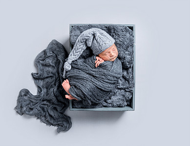 新生儿被黑毯子覆盖 头版睡眠童年女孩男生女性新生篮子孩子帽子休息图片