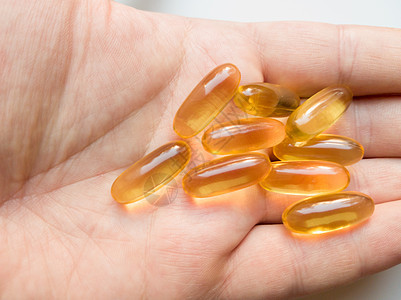 男性手持鱼肝油 omega-3 凝胶胶囊特写 手持胶囊欧米茄 3 或孤立在白色背景上的鱼油胶囊 保健理念图片