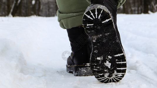穿着黑色靴子的女性腿 冬天在雪地里行走 活跃的女人在冬天的森林里从镜头前走开 专注于你的腿 美丽的白色冬季天气与新鲜的降雪冒险女图片