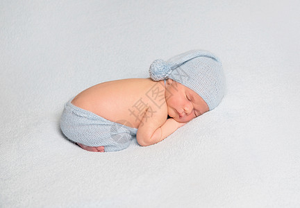 婴儿男孩卷在白毯子上蓝色女孩帽子睡眠肚子针织孩子新生男生地毯图片