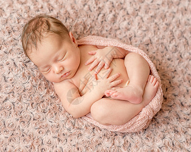 可爱的新生儿卷起来睡着 用粉色尿布包着说谎襁褓姿势童年男生生活孩子梦幻新生女孩图片