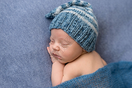 甜蜜睡着的新生婴儿戴帽子肖像孩子皮肤毯子童年身体灰色姿势蓝色梦幻生活图片