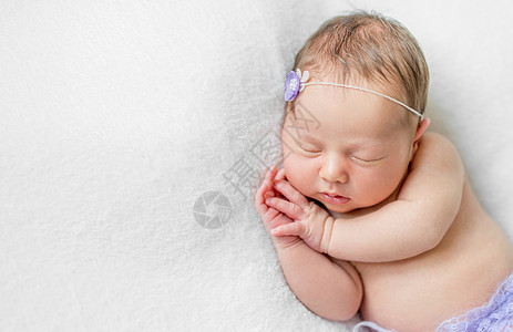可爱的新生女婴睡在头下 顶视线之下图片