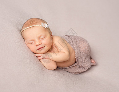 带着披肩的笑着 睡着的新生儿女孩图片