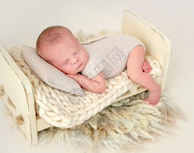 新生女婴睡在小床上成人毯子女孩童年婴儿玩具白色说谎孩子皮肤图片